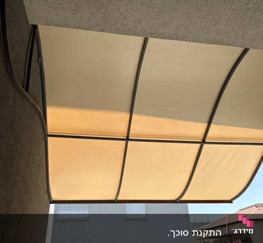 סוכך חיצוני על קיר בניין עם שמיים בהירים